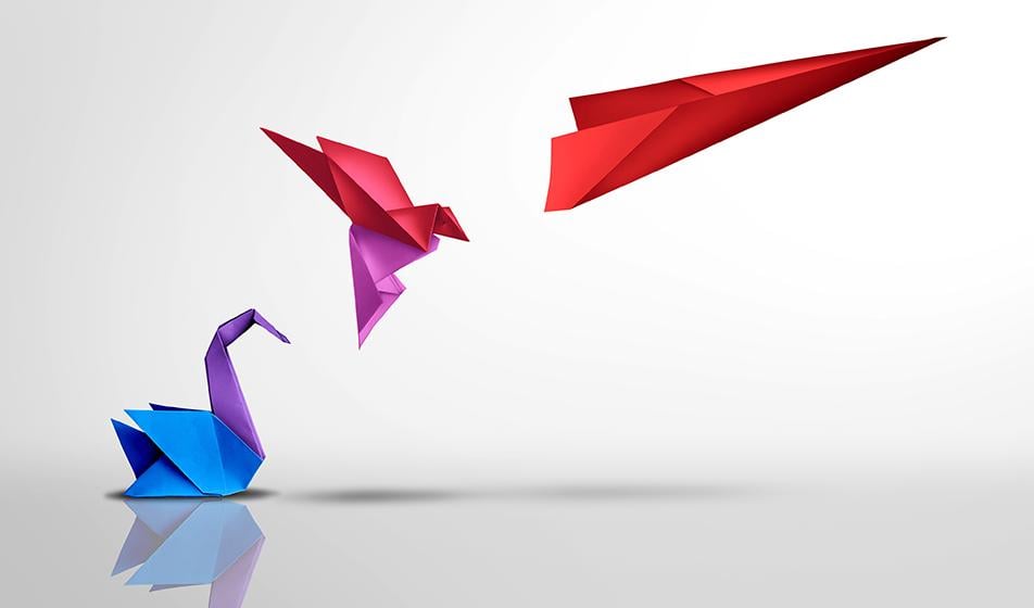 Three paper origami models are shown against a white background. The first is a swan, made of purple and blue paper. The second is a bird, hovering in mid-air, made of red and pink paper. The third is a red paper plane, soaring high. 