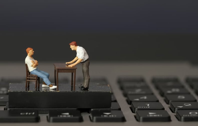 working online concept-miniature businessman boss angry with employee on laptop computer-min